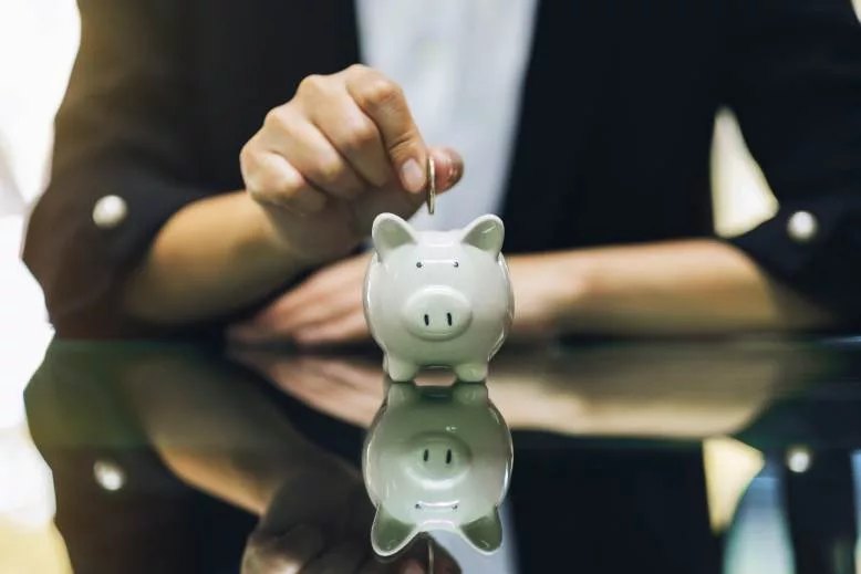 adding coins to a piggy bank