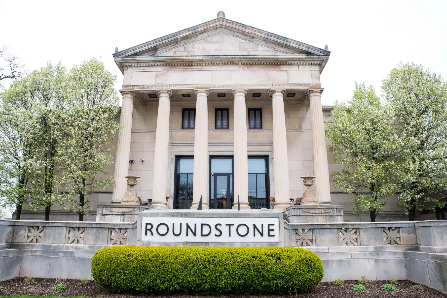 The exterior of the Roundstone headquarters building with the company sign and landscaping.