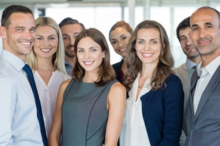 A group of smiling business professionals posing together.