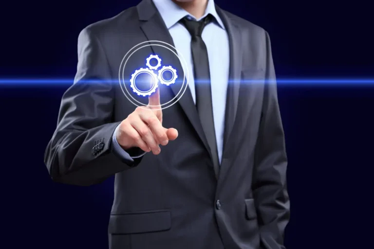 A businessman touching a glowing gears icon, representing technology and process.