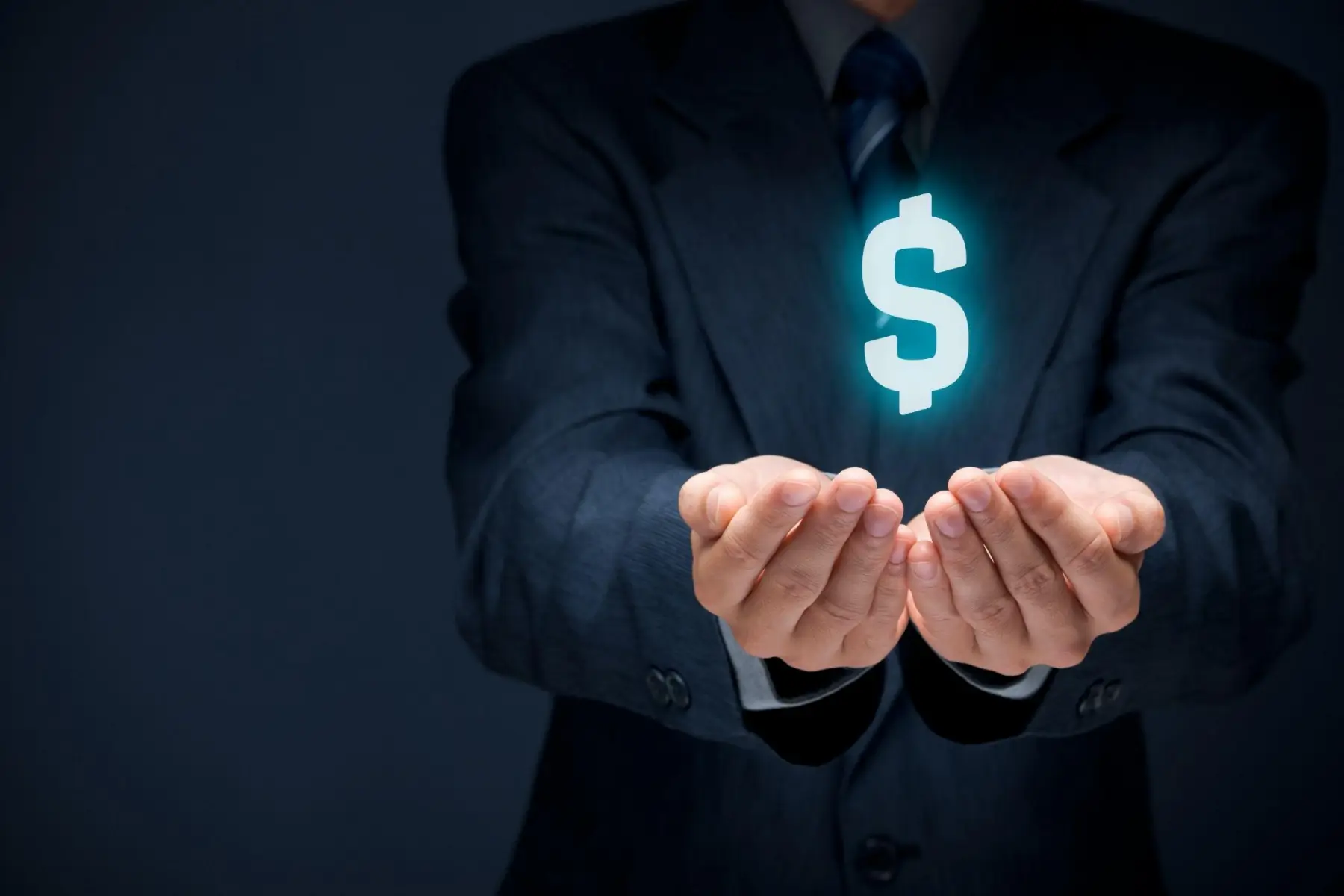 A businessman holding out cupped hands beneath a glowing dollar sign.