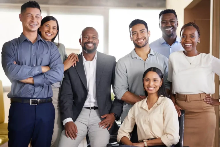 A diverse group of smiling business professionals posing together.