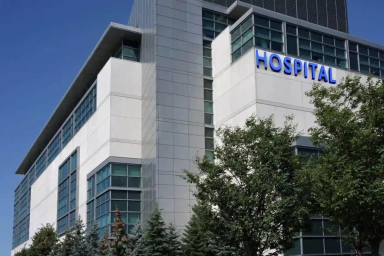 The exterior of a modern hospital building with trees in front.