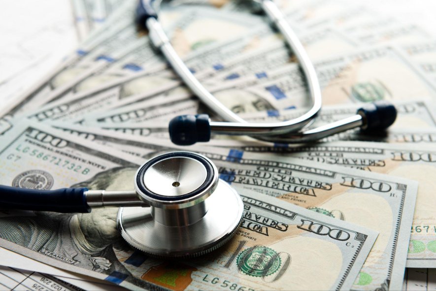 Cost containment in medical expenses depicted with money and stethoscope