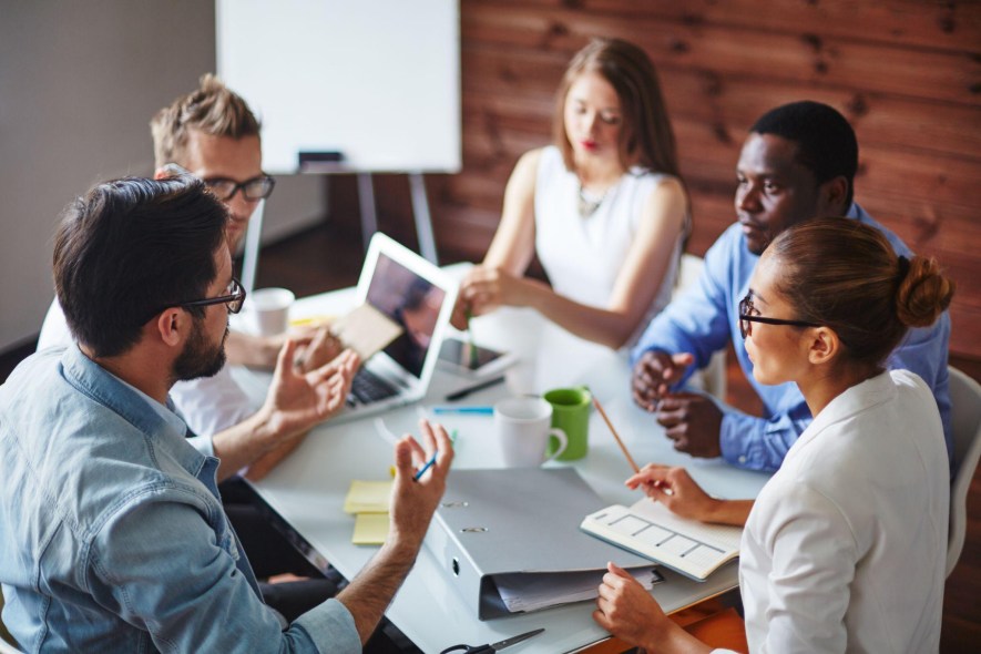 Team discusses cost containment strategies around a conference table