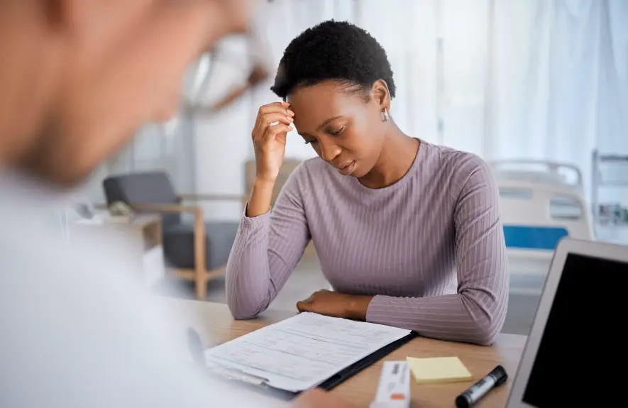 Woman reviewing employer health benefits paperwork at desk